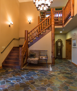 Log accents in the entry, walnut stairs and slate flooring.